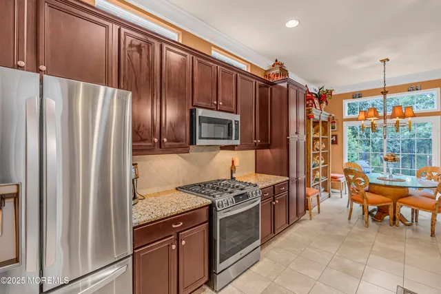 a kitchen with stainless steel appliances granite countertop a refrigerator and a stove top oven