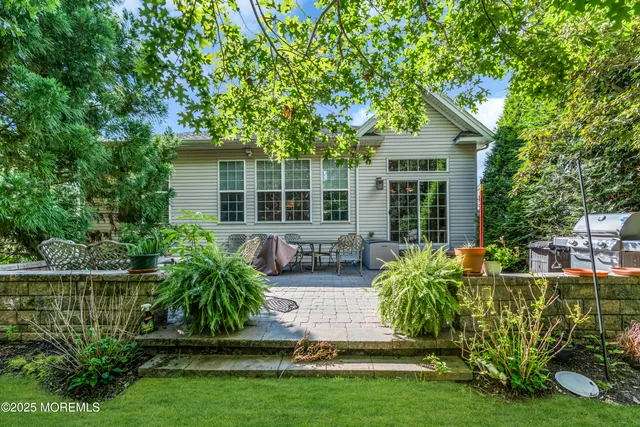 a view of a house with backyard sitting area and garden