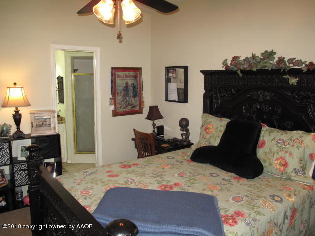 3509 West Point Drive Amarillo, TX 79121 - Photo 11 of 18 a bedroom with a bed and a chandelier