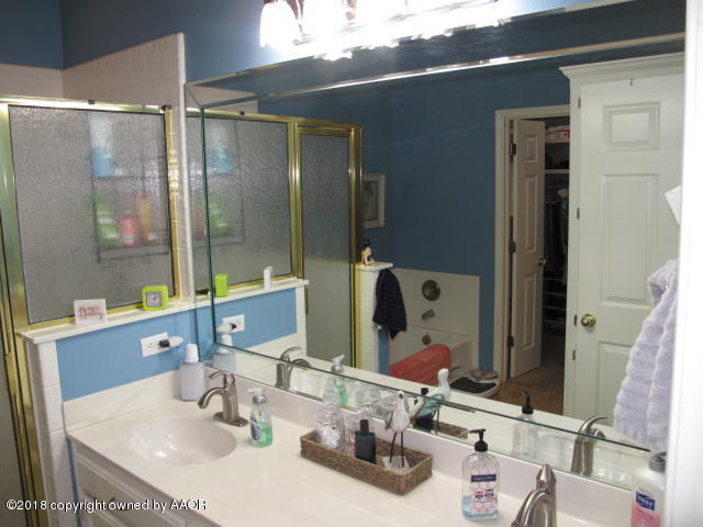 3509 West Point Drive Amarillo, TX 79121 - Photo 16 of 18 a bathroom with a sink and a mirror