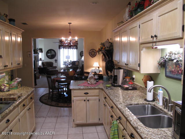 3509 West Point Drive Amarillo, TX 79121 - Photo 9 of 18 a kitchen with kitchen island granite countertop a sink a stove and cabinets