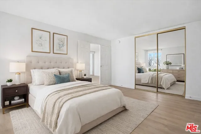 a bedroom with a large bed and a large mirror