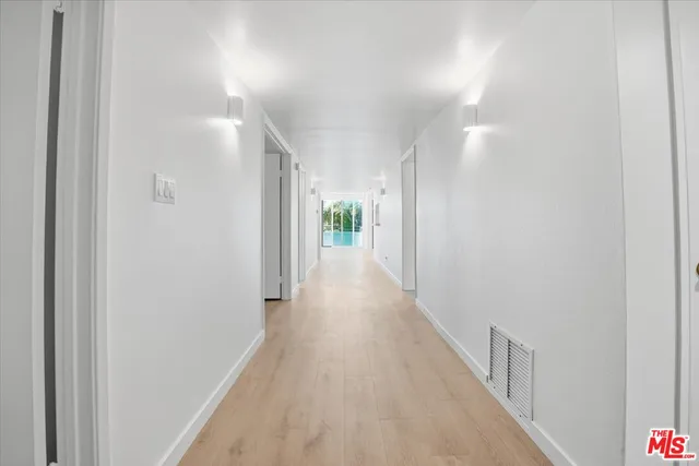 a view of a hallway with wooden floor
