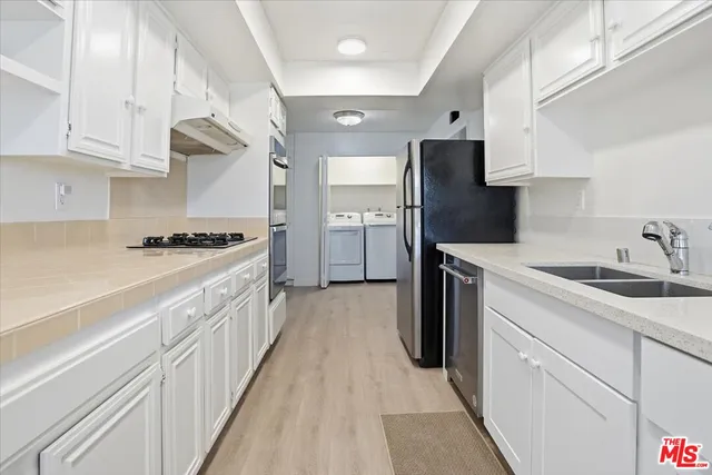 a kitchen with cabinets and stainless steel appliances
