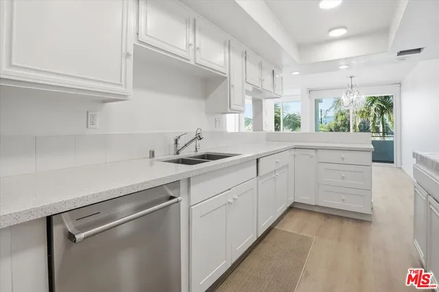 a kitchen with white cabinets and sink