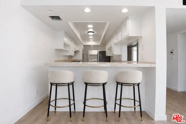 a hall with kitchen island a sink and a stove