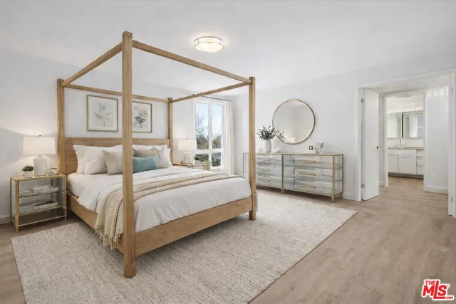 a bedroom with a bed mirror and a window