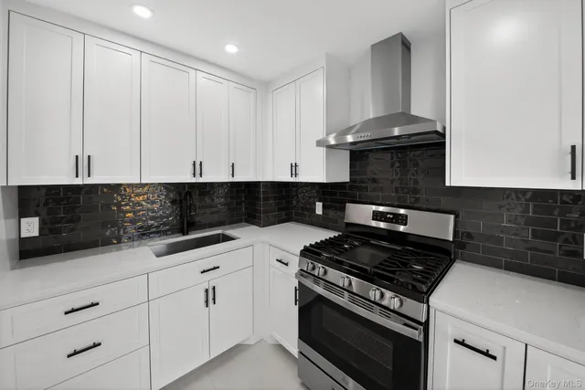 a kitchen with white cabinets and appliances