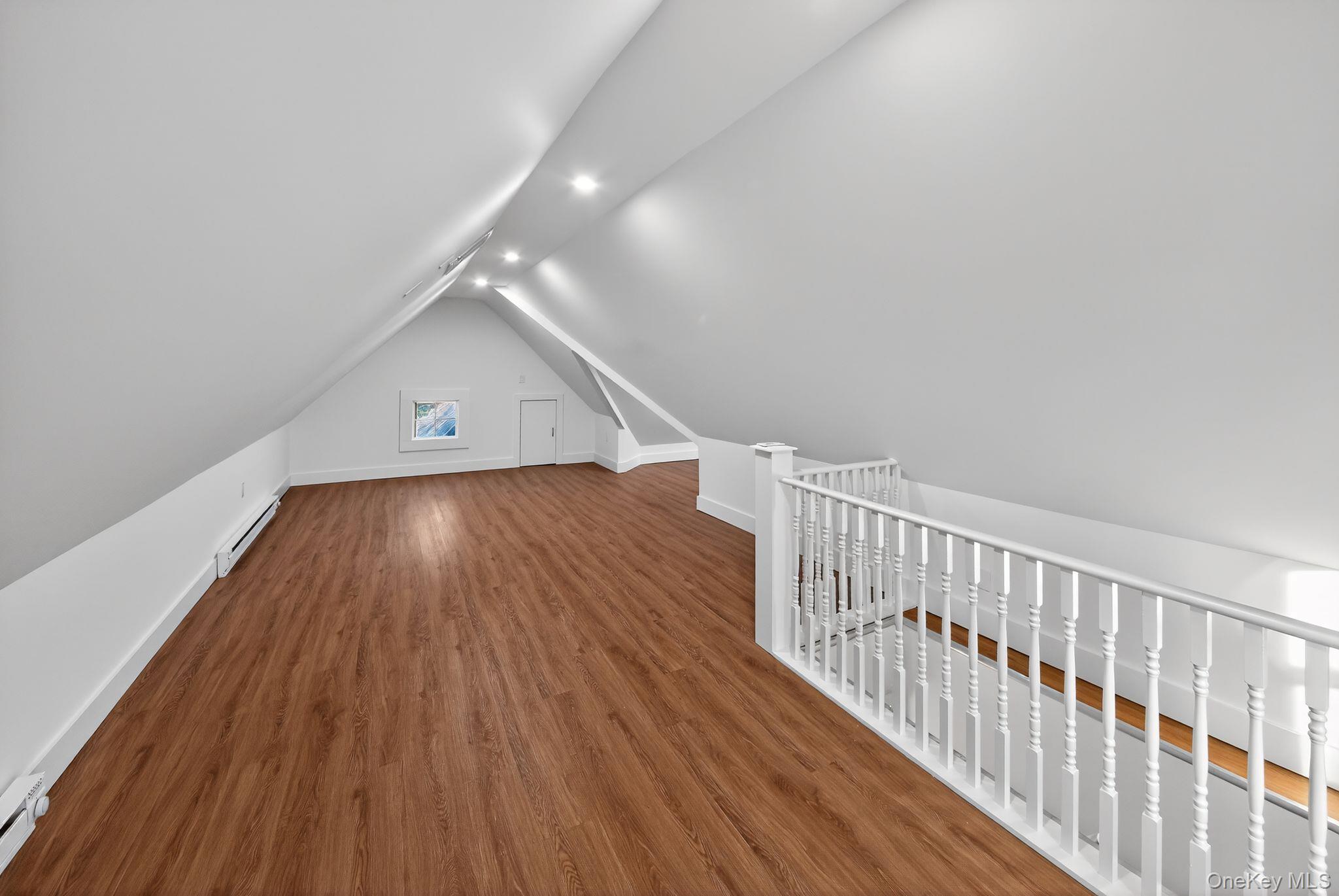 153 Franklin Avenue, Unit 2 Pearl River, NY 10965 - Photo 22 of 25 Additional living space featuring wood finished floors, a baseboard heating unit, vaulted ceiling, and recessed lighting