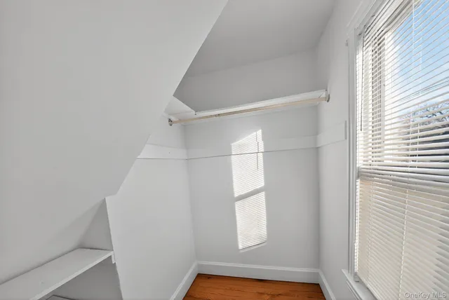 a view of small space with racks on the wall and a window