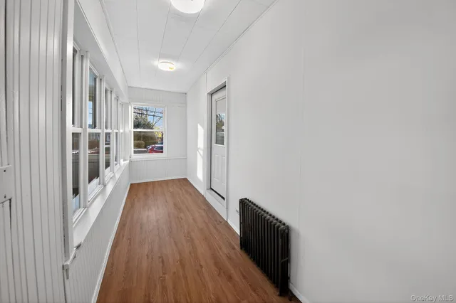 a view of hallway with wooden floor and stairs