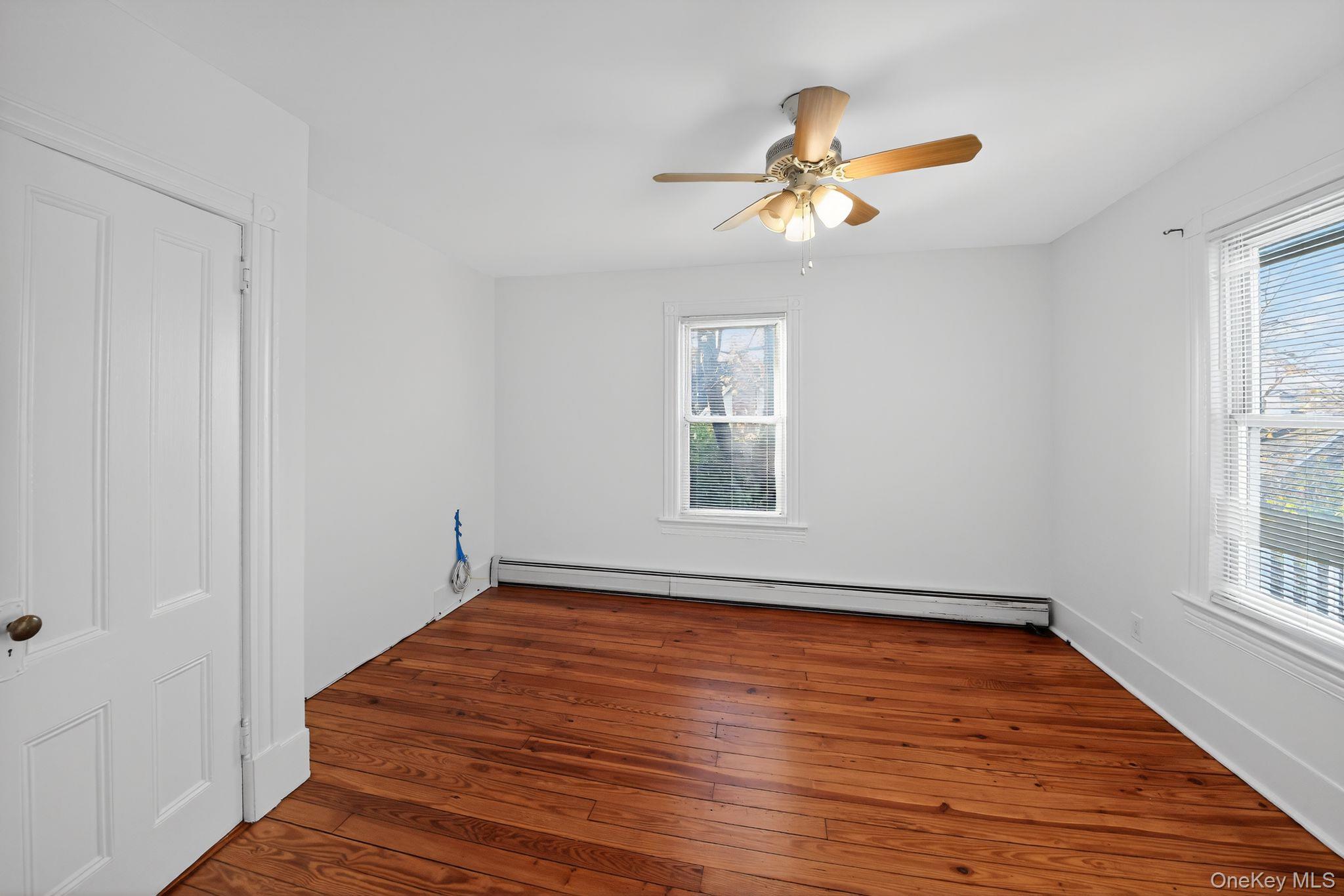 153 Franklin Avenue, Unit 2 Pearl River, NY 10965 - Photo 7 of 25 Spare room with dark wood-style flooring, a baseboard radiator, and a ceiling fan
