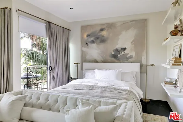 a bedroom with a large bed and a painting on the wall