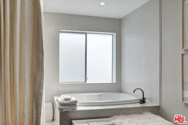 a bathroom with a bathtub and a window