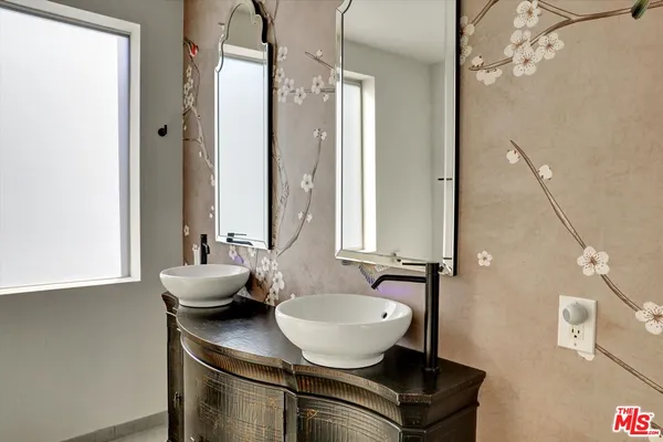 a bathroom with a sink a mirror and a window