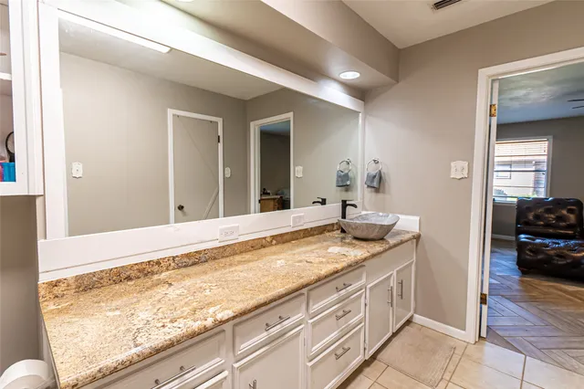 a bathroom with a granite countertop sink and a mirror
