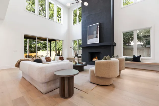 a living room with furniture a large window and a fireplace
