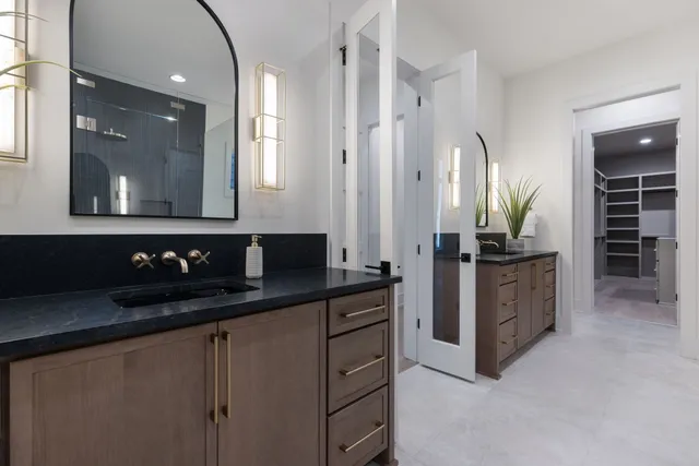 a bathroom with double vanity and two mirror