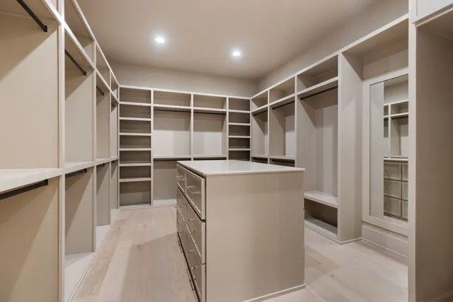 a view of walk in closet with empty racks