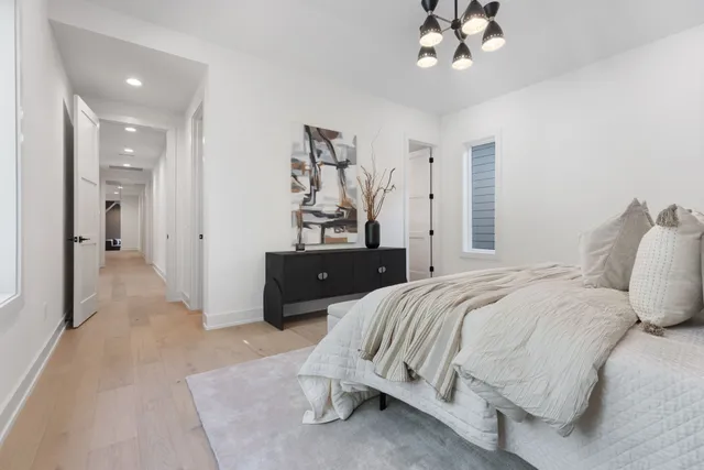 a spacious bedroom with a bed and a chandelier