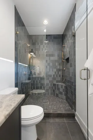 a bathroom with a shower a toilet and a sink