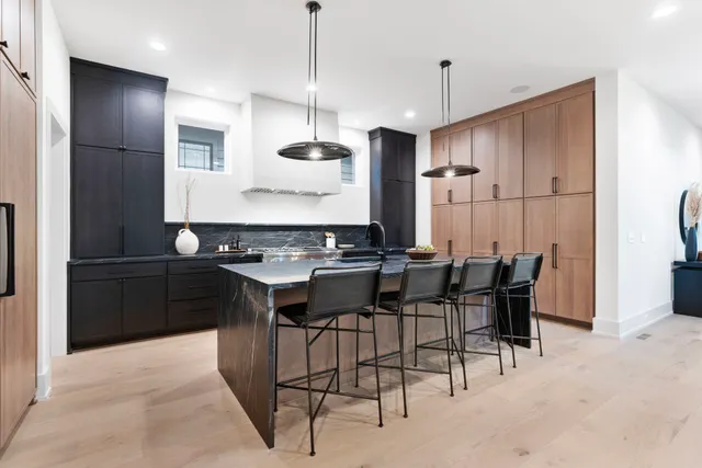 a kitchen with stainless steel appliances kitchen island a table and chairs in it