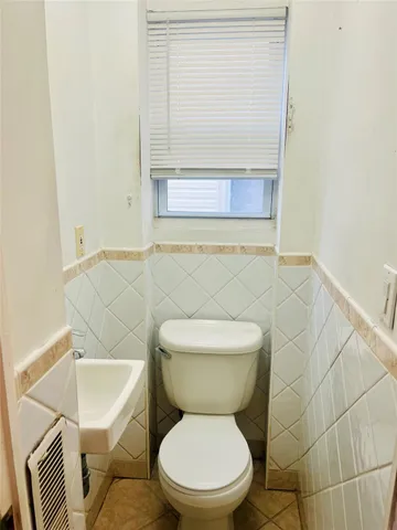 a white toilet sitting next to a bathroom sink