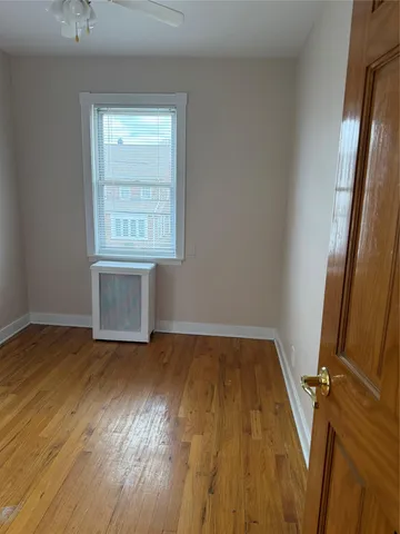 an empty room with wooden floor and window