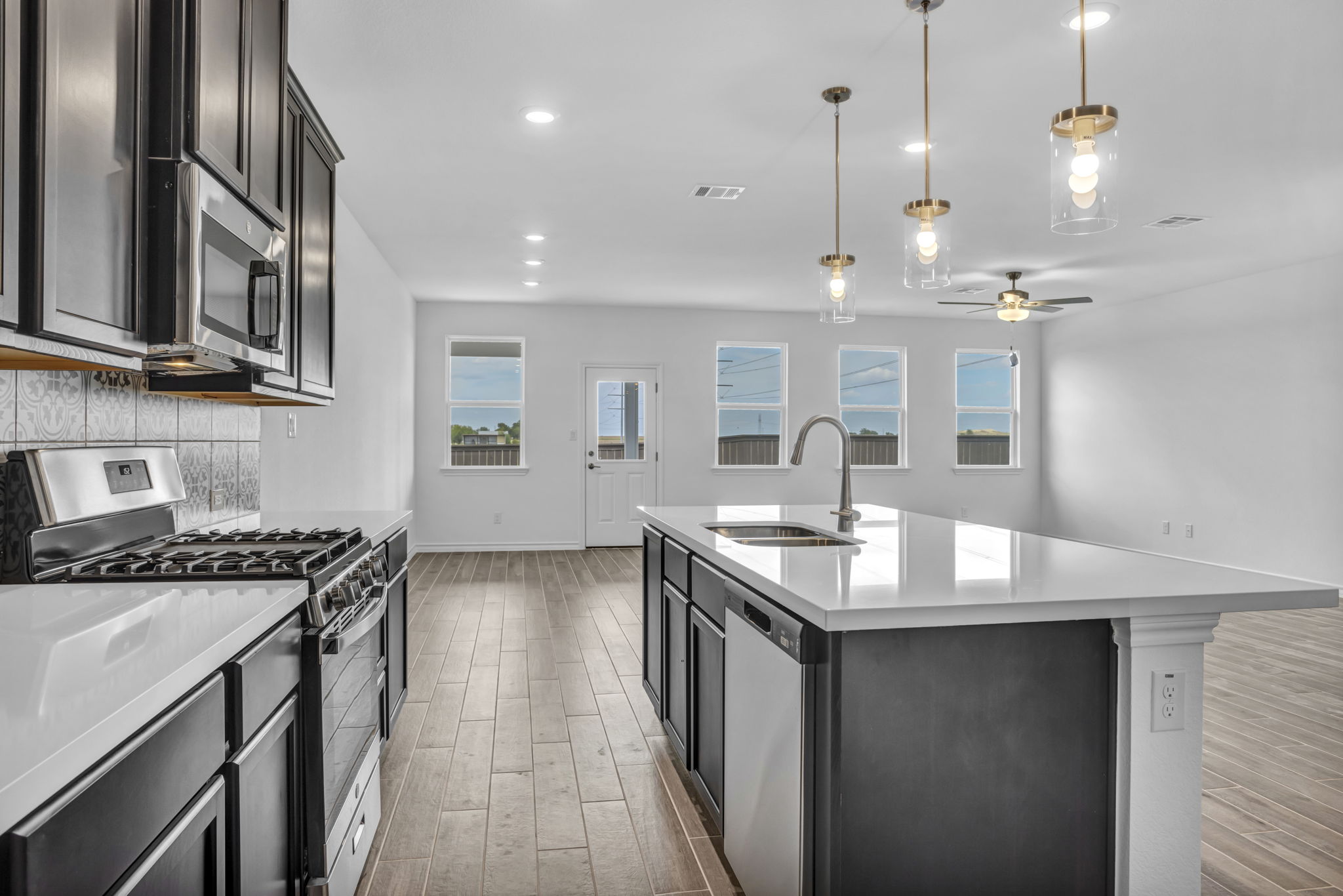 131 Adeline Road Hutto, TX 78634 - Photo 16 of 30 A well-appointed kitchen showcasing a central island, modern appliances, and seamless flow into a living area.