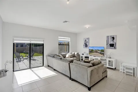a living room with furniture and a dining table with kitchen view