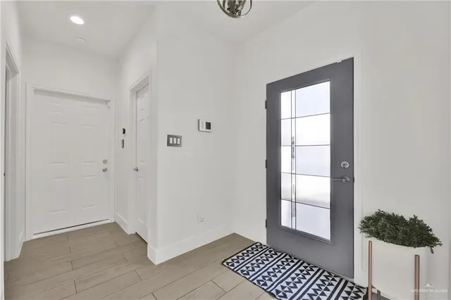 a living room with couches and kitchen view with wooden floor