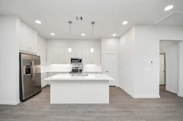 a large kitchen with a table and chairs
