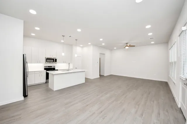 a kitchen with a sink chandelier and wooden floor