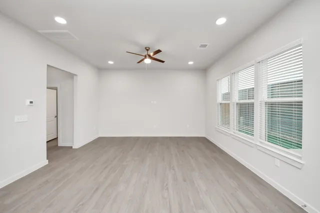 a kitchen with a stove a sink and a flat screen tv
