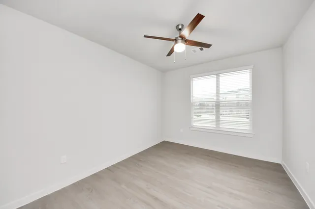 wooden floor in an empty room with a kitchen