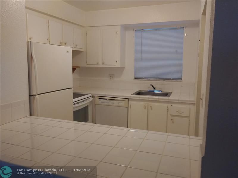 6501 Winfield Boulevard, Unit A11A Margate, FL 33063 - Photo 4 of 10 a kitchen with white cabinets and refrigerator