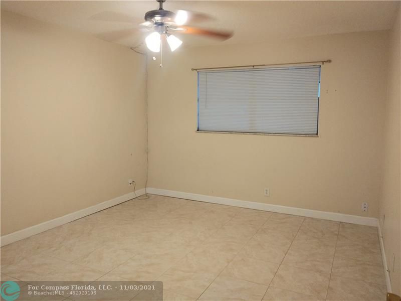 6501 Winfield Boulevard, Unit A11A Margate, FL 33063 - Photo 6 of 10 an empty room with a chandelier fan