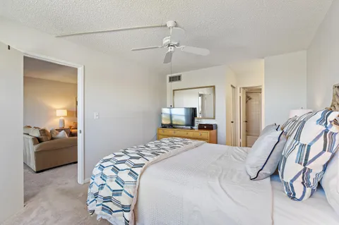 a bedroom with a bed lamps and a large window