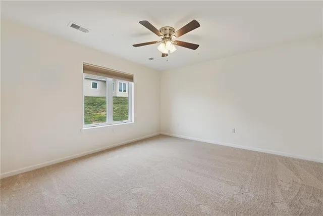 an empty room with window and ceiling fan