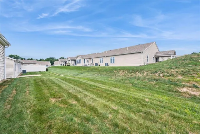 a view of a house with a yard and sitting area