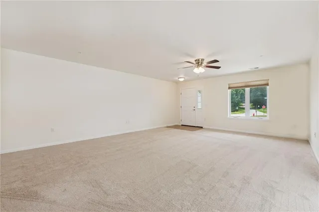 an empty room with a window and a ceiling fan