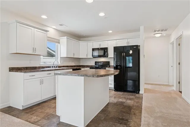 a kitchen with a refrigerator sink and cabinets