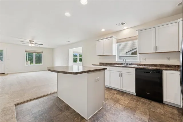 a kitchen with granite countertop a stove top oven sink and cabinets