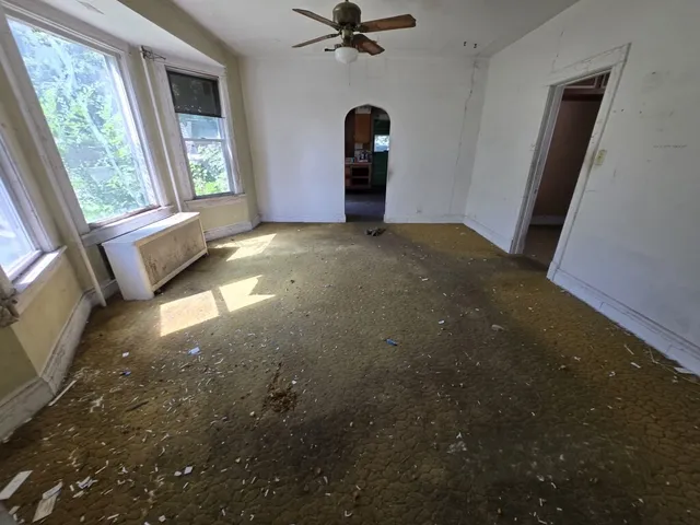 a view of a livingroom with a ceiling fan and window