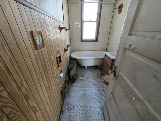 a bathroom with a sink a toilet a window and shower