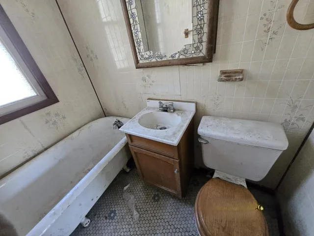 a bathroom with a toilet sink and mirror