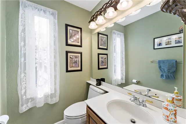 a bathroom with a sink vanity mirror and toilet