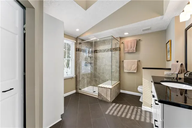 a bathroom with a double vanity sink toilet and shower