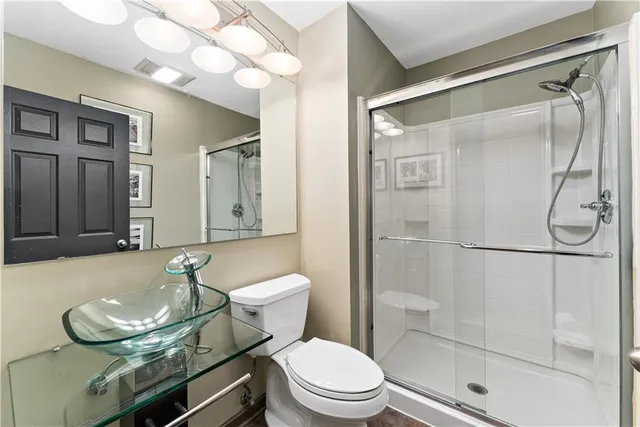 a bathroom with a sink a toilet and shower