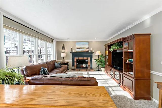 a living room with furniture large window and a fireplace